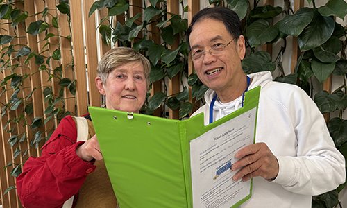 Tom Wong and Helen Smith check bookings in the Appy Hour folder